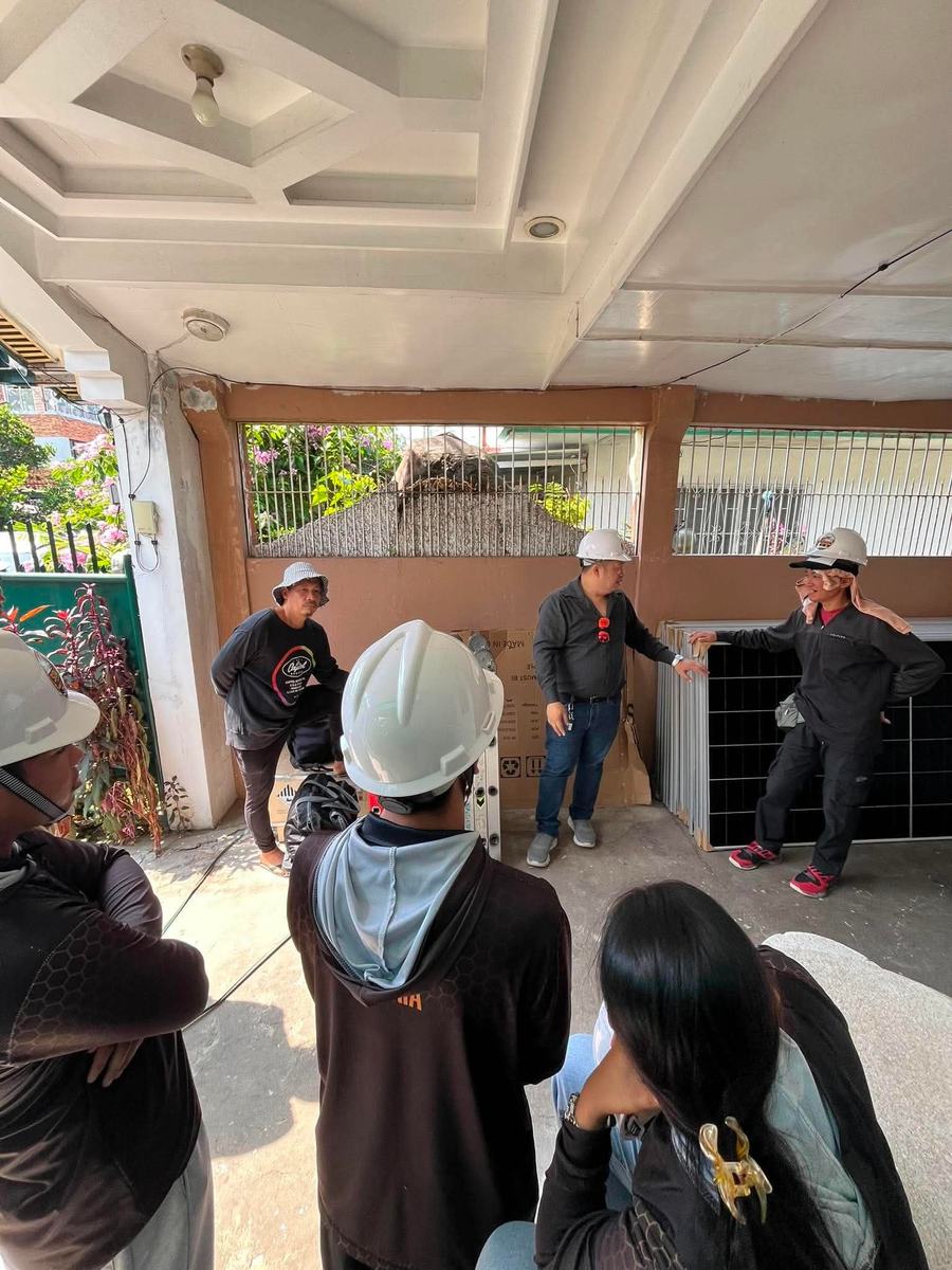 SolarWave crew in hard hats gathered for a briefing at a job site